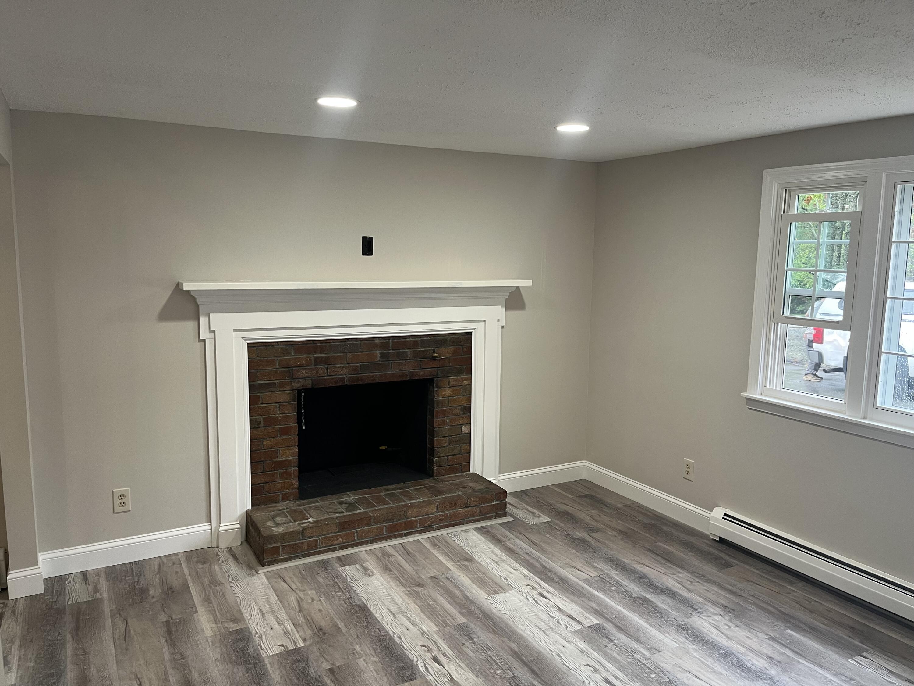 49 Burnham Street Barnstable, MA 02648 - Photo 17 of 17 an empty room with wooden floor a fireplace and windows