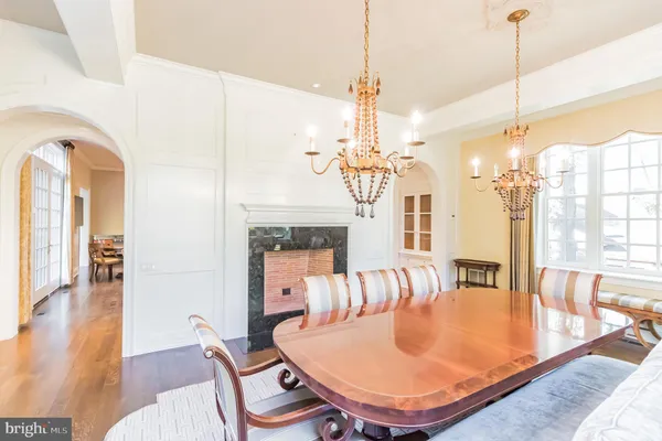 a open kitchen with stainless steel appliances granite countertop a stove a refrigerator dining table and chairs with wooden floor
