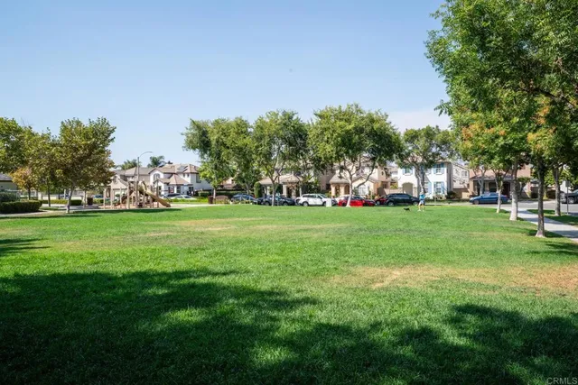 a front view of a house with a garden and lake view