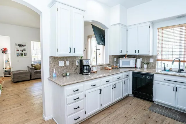 a kitchen with granite countertop a refrigerator stove and sink