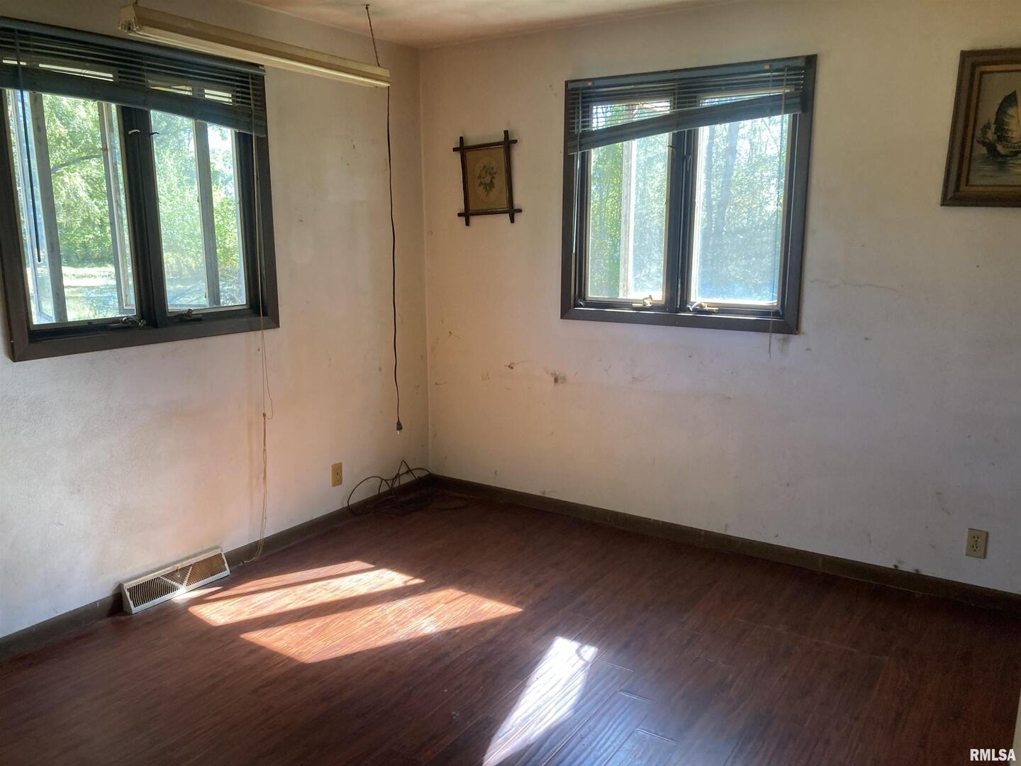 28597 Ropp Road Geneseo, IL 61254 - Photo 10 of 25 an empty room with wooden floor and windows