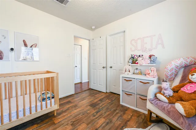 a room with furniture a baby crib and a dresser