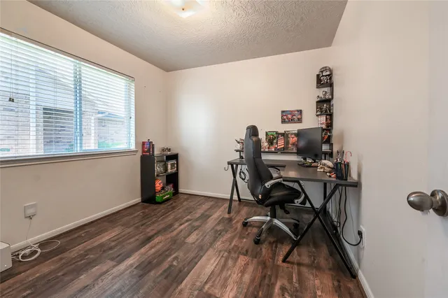 a view of a workspace with furniture and a window
