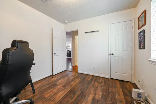 a view of a hallway with wooden floor and closet