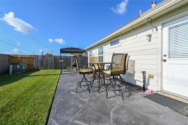 a view of a patio with table and chairs and garden