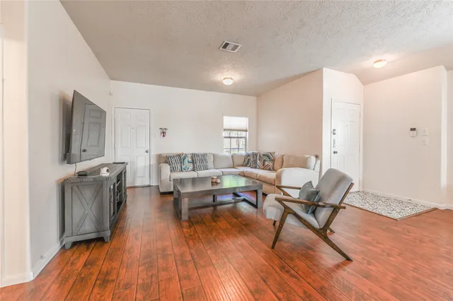 a living room with furniture and a wooden floor