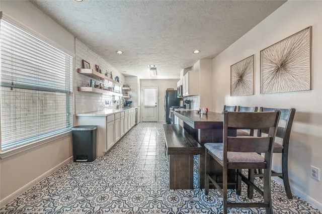 a kitchen with stainless steel appliances kitchen island granite countertop a table chairs in it and wooden floors