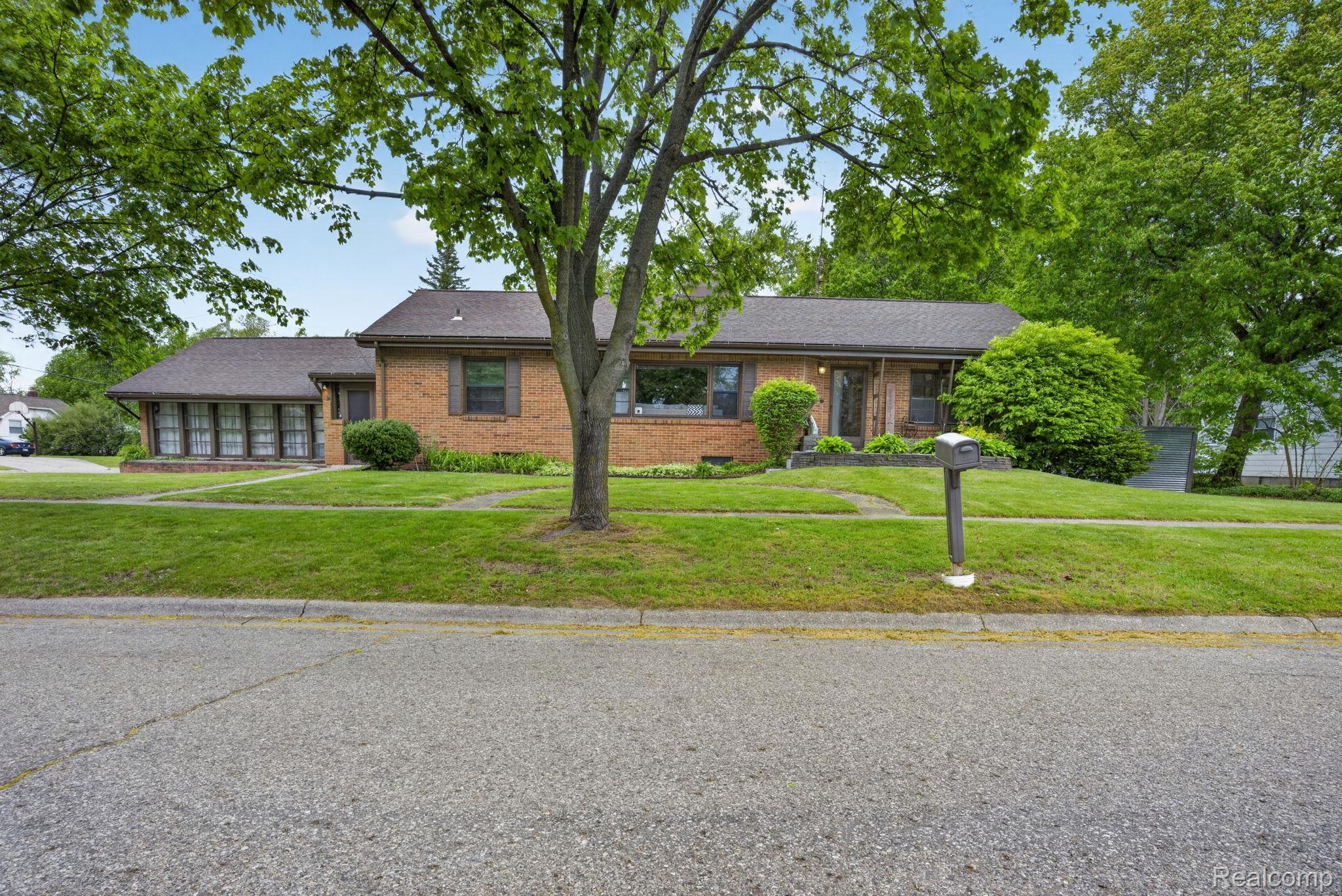 1209 Beatrice Street Flushing, MI 48433 - Photo 4 of 39 Ranch-style house with a front yard, brick siding, and a porch