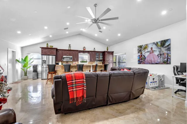 a living room with furniture kitchen view and a chandelier