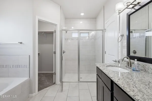 a bathroom with a granite countertop bathtub sink and mirror