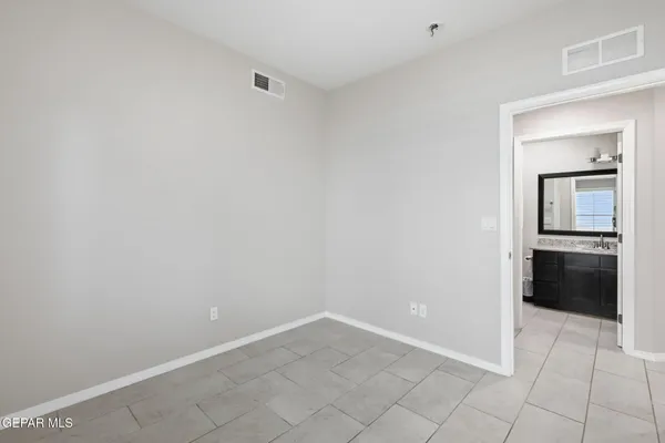 an empty room with windows and chandelier fan