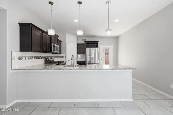 a large kitchen with a refrigerator stove and sink