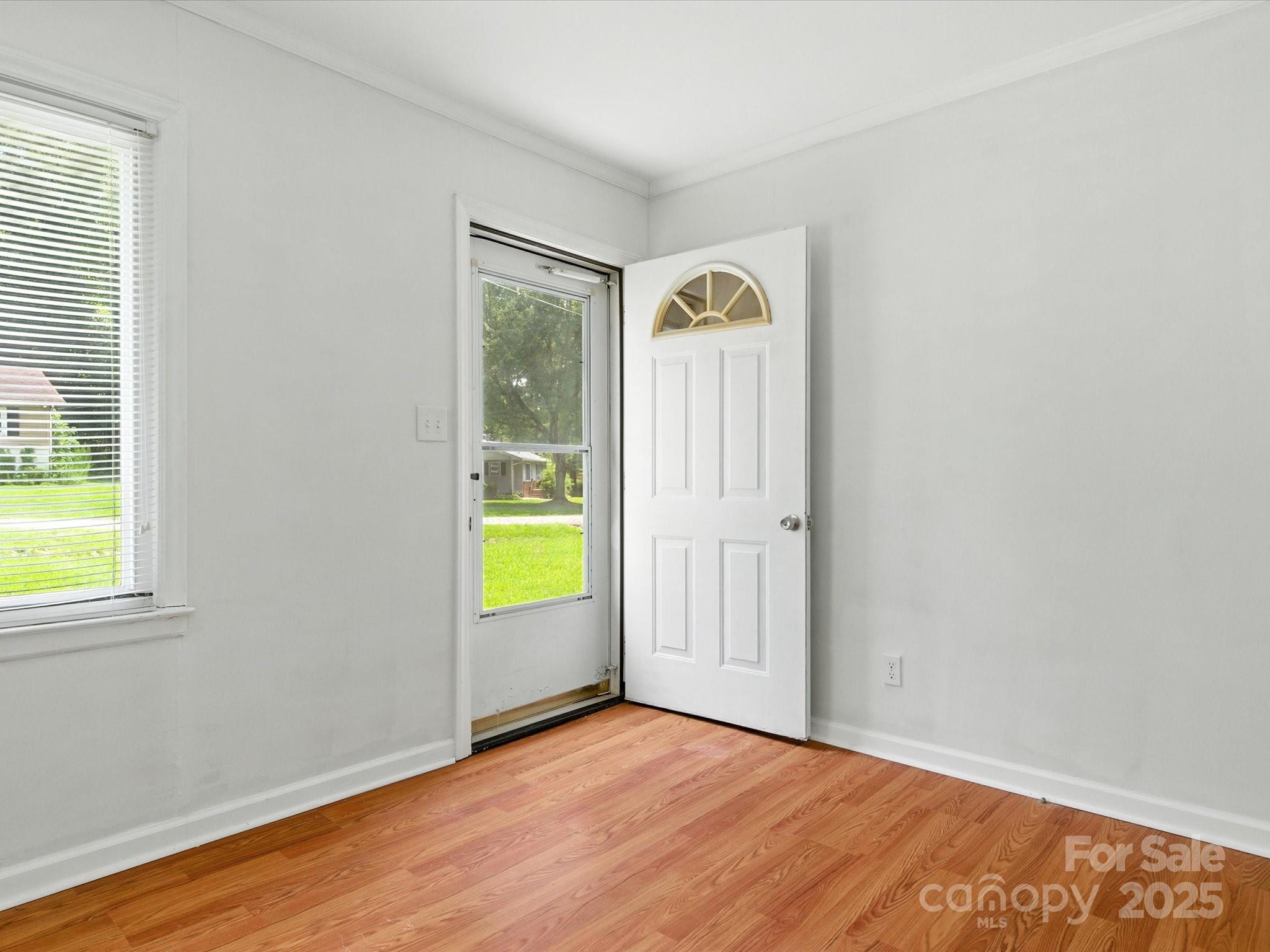 308 Taylor Drive Stanley, NC 28164 - Photo 3 of 26 a view of an empty room with a window and wooden floor