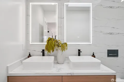 a bathroom with double vanity sink and a mirror