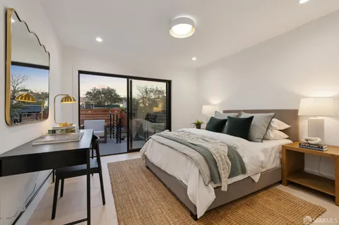 a bedroom with a large bed and a desk