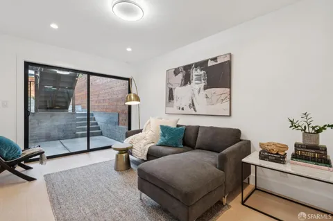a living room with furniture and a glass door