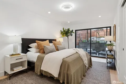 a spacious bedroom with a bed and a potted plant