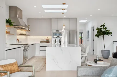 a kitchen with stainless steel appliances kitchen island granite countertop a sink a stove and a refrigerator