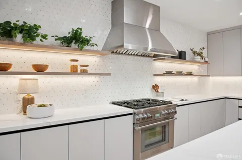 a kitchen with stainless steel appliances granite countertop a sink stove and cabinets