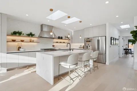 a kitchen with stainless steel appliances kitchen island granite countertop a refrigerator and microwave