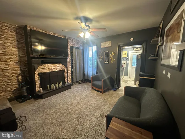 a living room with furniture a flat screen tv and a fireplace