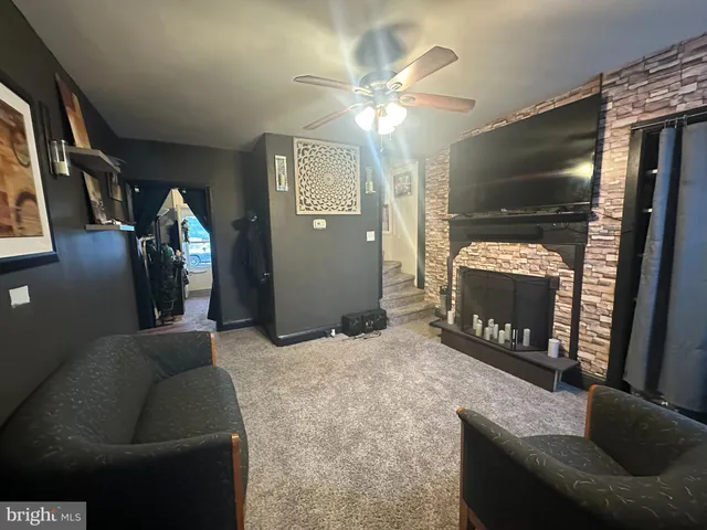 a living room with furniture a fireplace and a flat screen tv