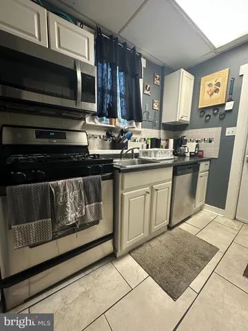 a kitchen with stainless steel appliances granite countertop a stove top oven a sink dishwasher and a microwave