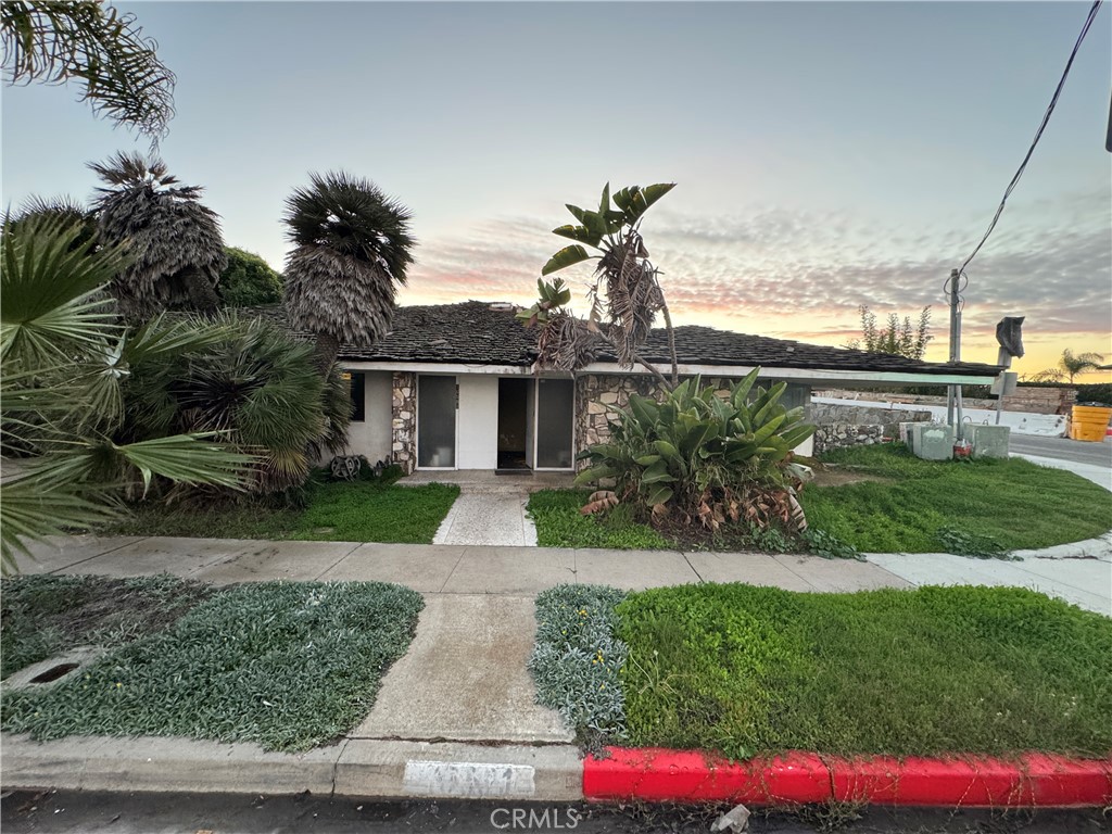 16591 Channel Huntington Beach, CA 92649 - Photo 2 of 11 a front view of a house with a yard and potted plants