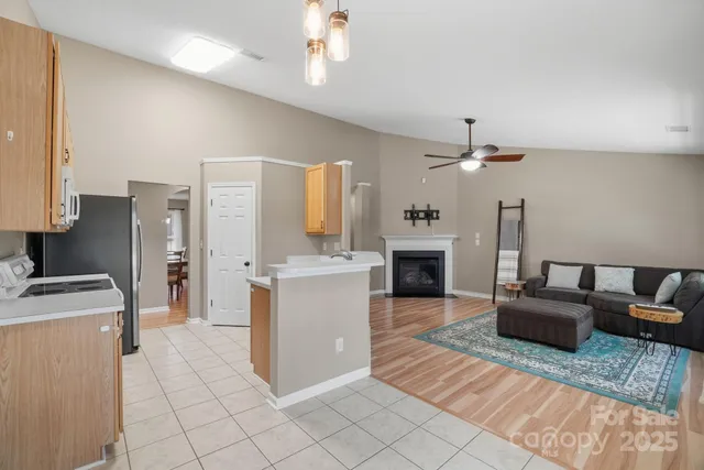 a living room with furniture a fireplace and a chandelier