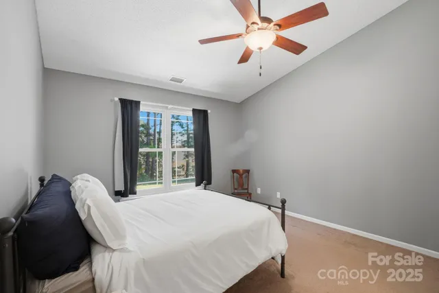 a bedroom with a bed and a large window