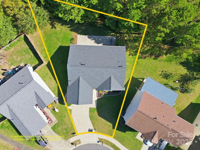 an aerial view of a house with a yard and swimming pool