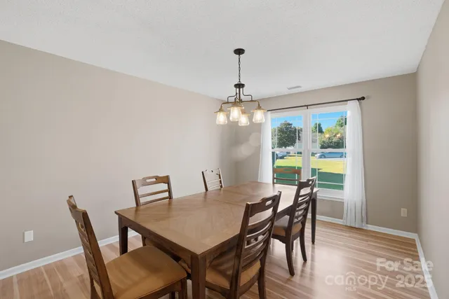 a view of a dining room with furniture a chandelier and wooden floor
