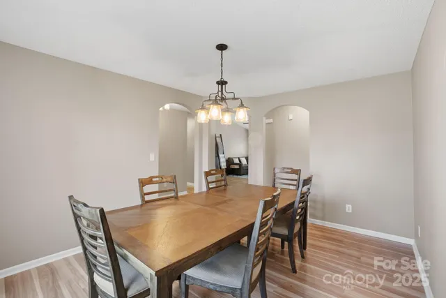 a dining room with furniture a chandelier and wooden floor