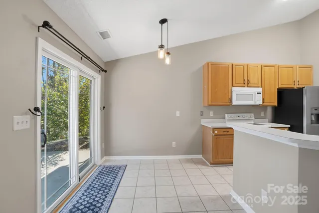 a kitchen with stainless steel appliances a stove top oven a sink a refrigerator and a granite counter tops