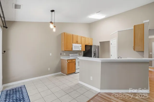 a view of a kitchen with a sink and dishwasher a refrigerator with wooden floor