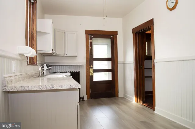 a kitchen with granite countertop a sink stove and cabinets