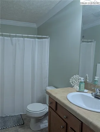 a bathroom with a granite countertop sink toilet and a mirror