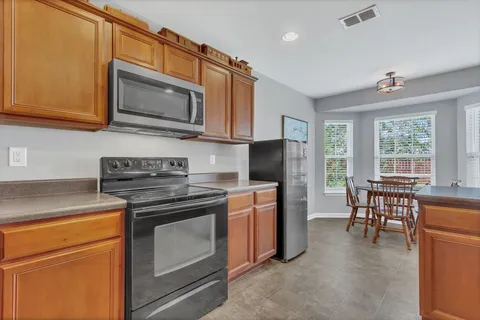 a kitchen with stainless steel appliances granite countertop a stove microwave refrigerator sink and cabinets