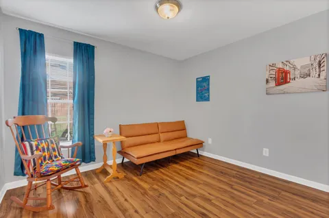 a living room with furniture and a wooden floor