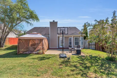 a view of a house with backyard and sitting area