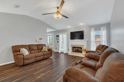 a living room with furniture a fireplace and a flat screen tv