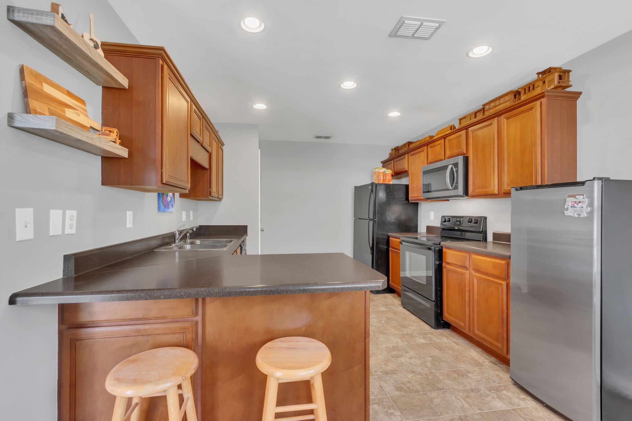 2032 Red Jacket Trace Spring Hill, TN 37174 - Photo 9 of 33 a kitchen with stainless steel appliances granite countertop a sink a stove a refrigerator cabinets and chairs