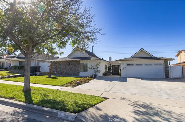 a view of a house with backyard and a tree