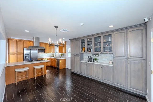 a living room with furniture wooden floor and a kitchen view