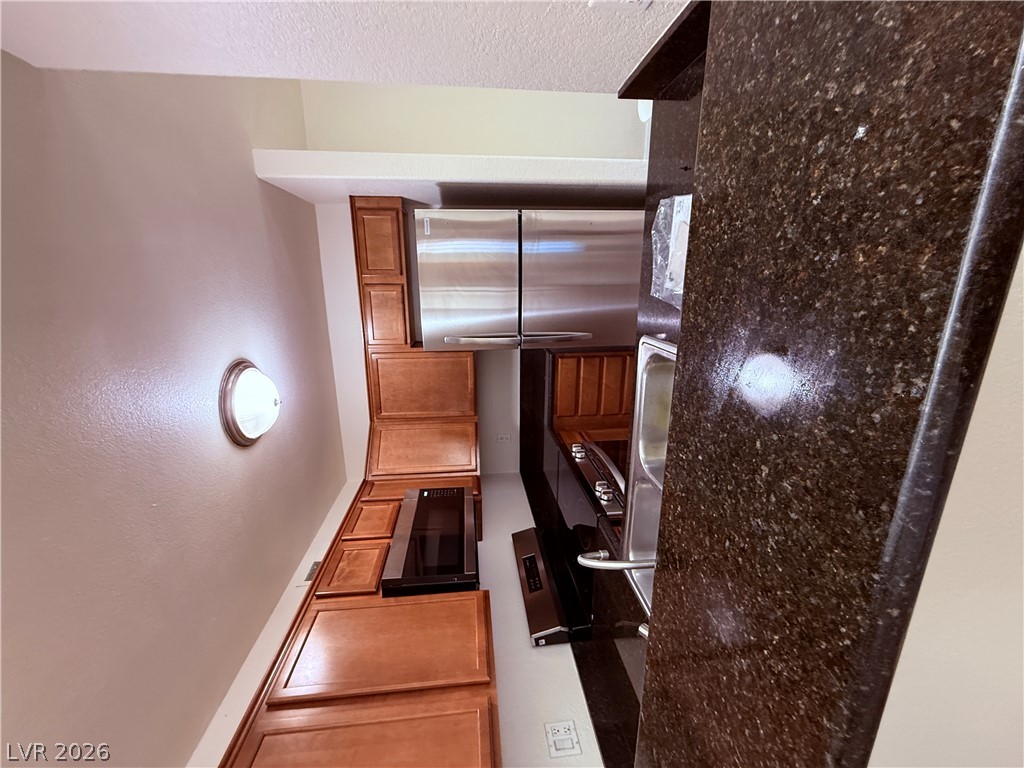 9325 West Desert Inn Road, Unit 260 Las Vegas, NV 89117 - Photo 11 of 42 Culinary delights await in this modern kitchen with rich cabinetry and polished granite countertops.
