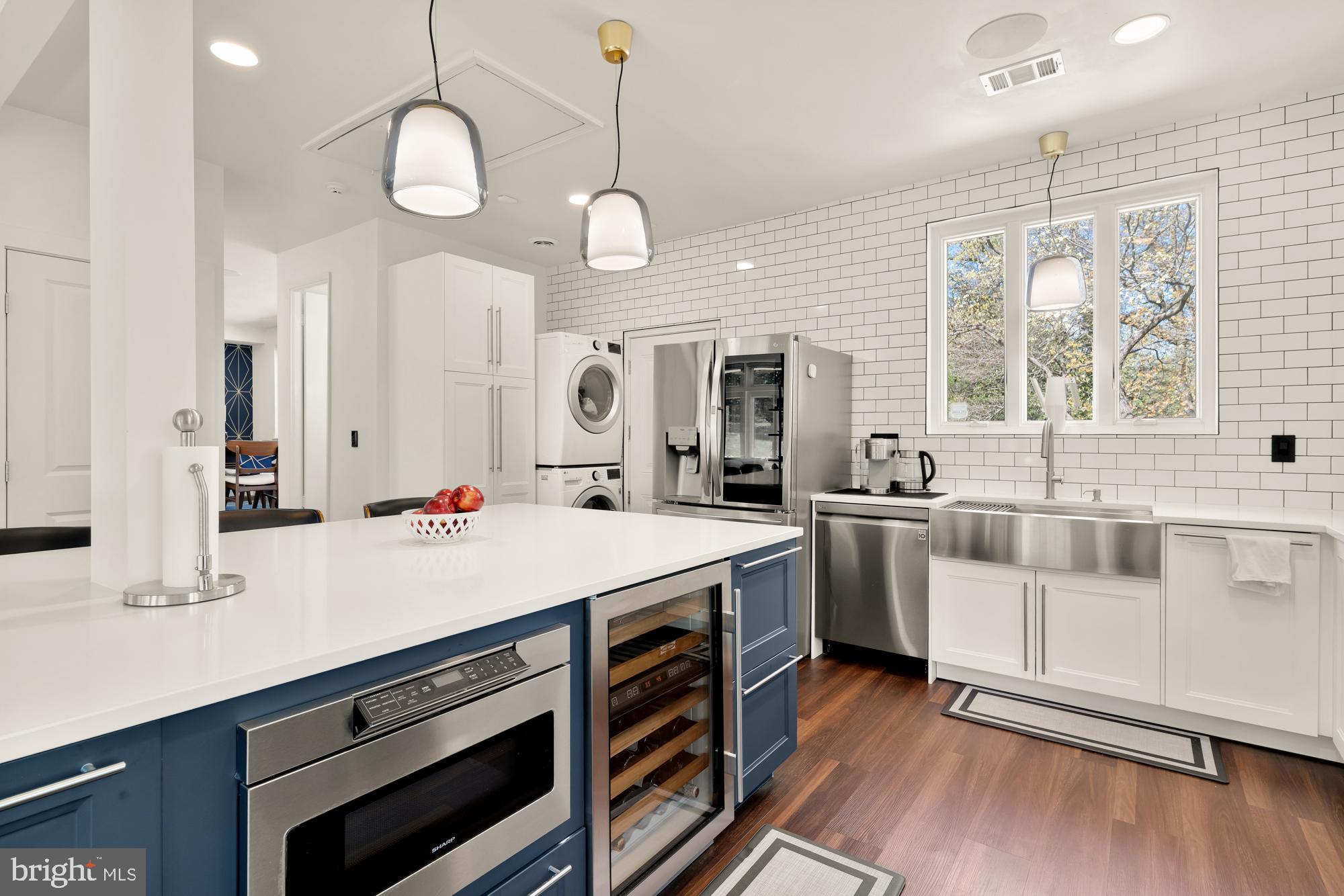 1736 Overlook Drive Silver Spring, MD 20903 - Photo 17 of 42 a large white kitchen with a large window a sink and stainless steel appliances