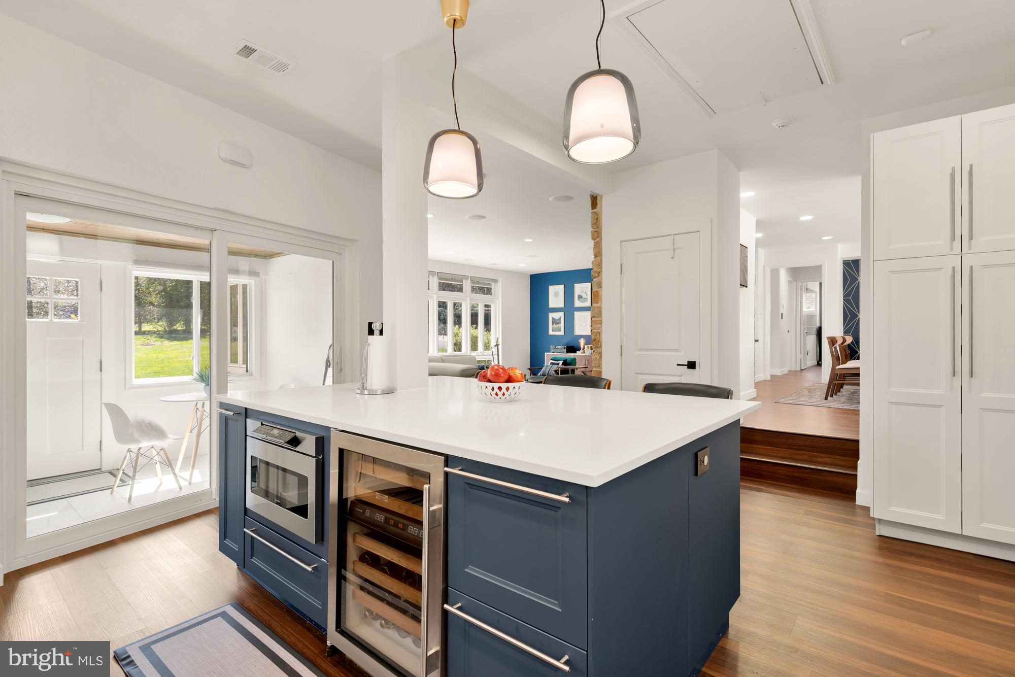 1736 Overlook Drive Silver Spring, MD 20903 - Photo 18 of 42 a large kitchen with kitchen island a stove a sink a refrigerator and a dining table with wooden floor