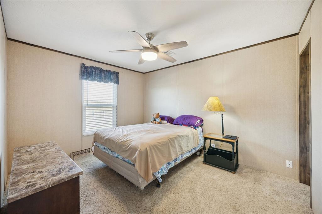 10240 Norrell Road Venus, TX 76084 - Photo 13 of 22 a bedroom with a bed and a chandelier