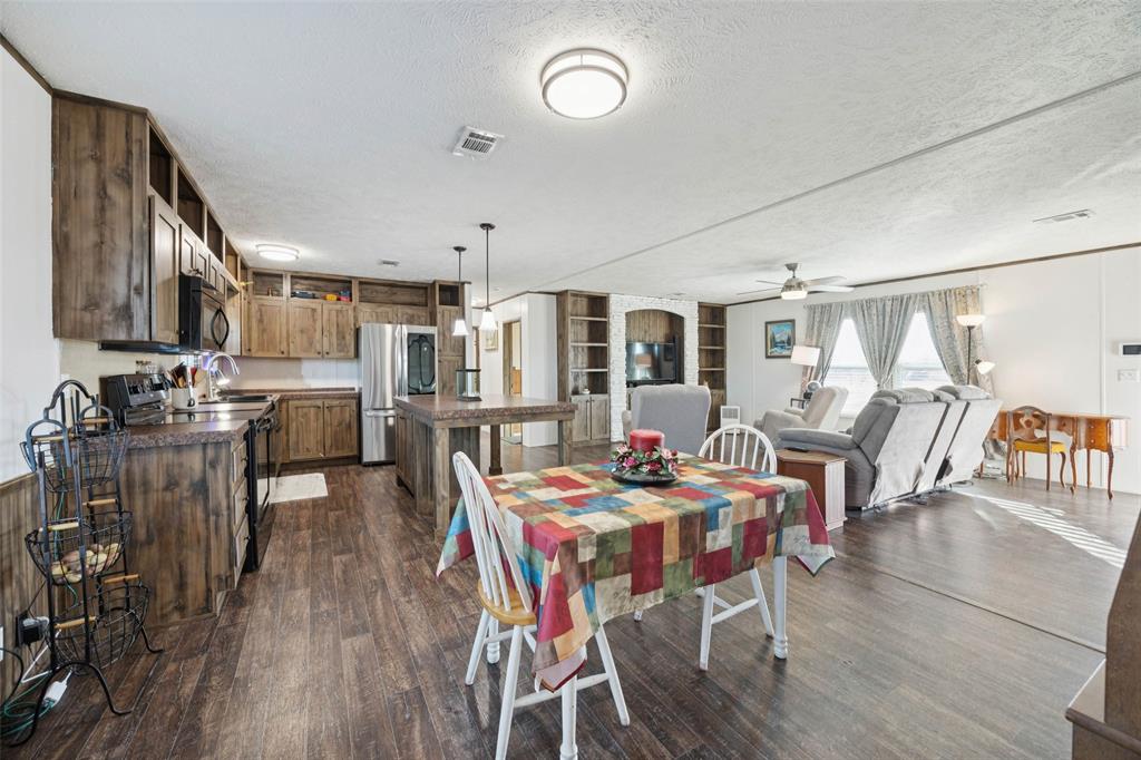 10240 Norrell Road Venus, TX 76084 - Photo 5 of 22 a outdoor dining space with lots of wooden furniture and stainless steel appliances