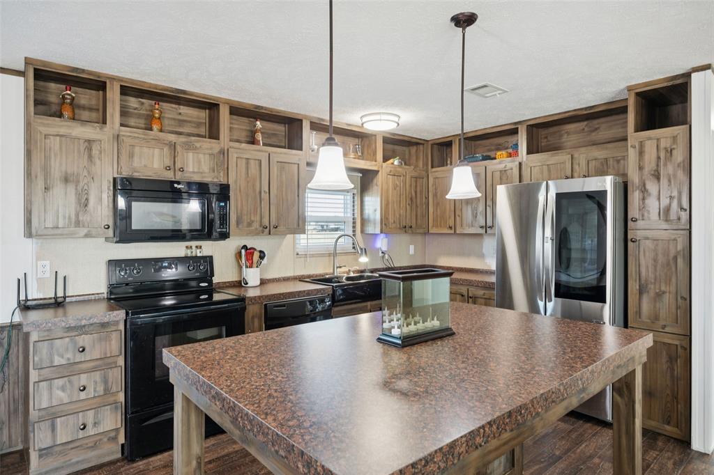 10240 Norrell Road Venus, TX 76084 - Photo 6 of 22 a kitchen with stainless steel appliances granite countertop a sink a stove and refrigerator